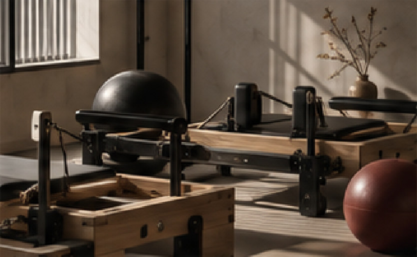 Wooden Pilates reformers in a sunlit studio